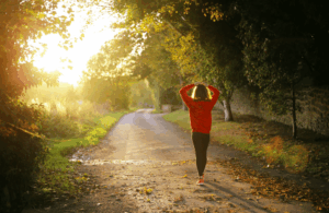 woman walking down path in forest